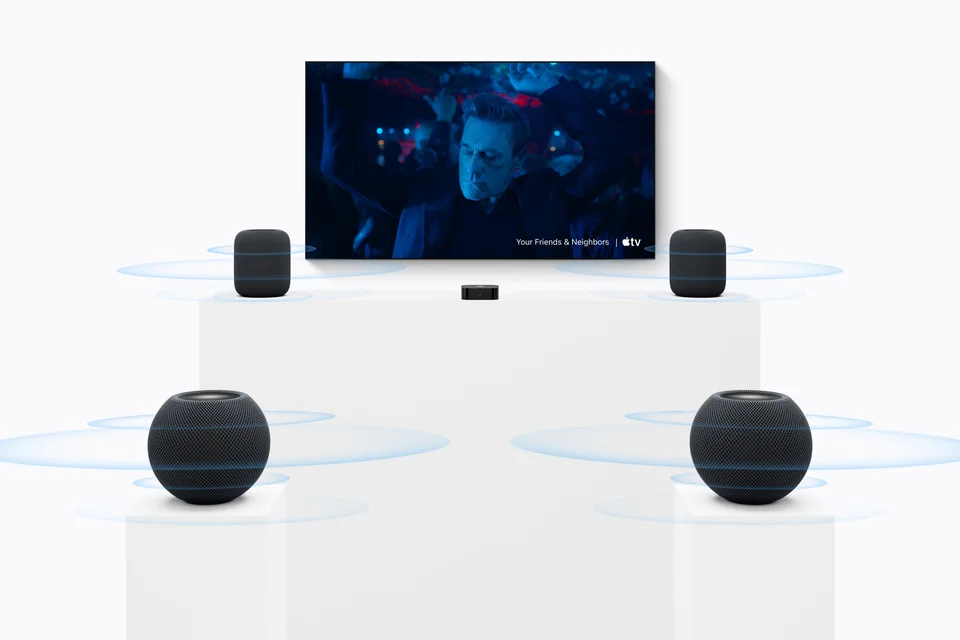 Heimkino mit Fernseher und Apple TV, vorn zwei große HomePod, hinten zwei HomePod mini in Schwarz