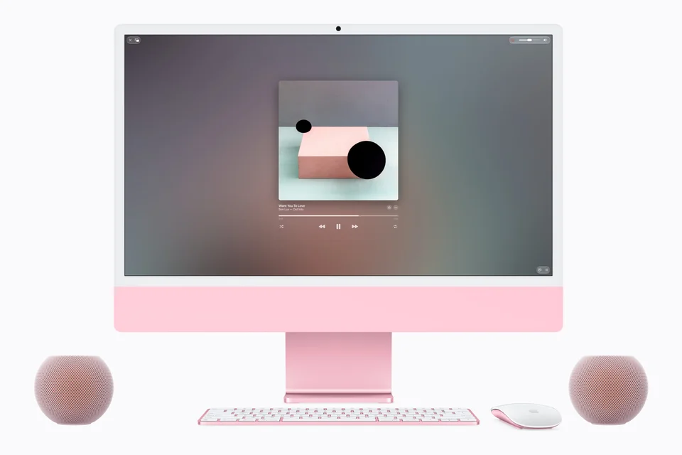 Rosa iMac auf weißem Grund, links und rechts je ein rosa Lautsprecher als Stereopaar