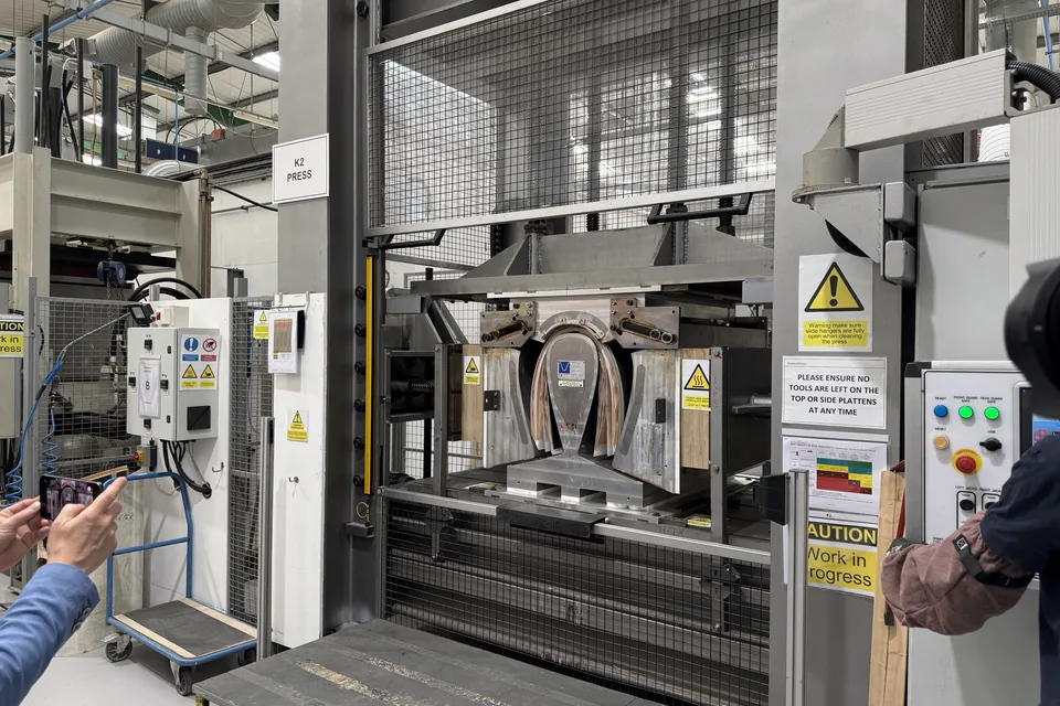 Hydraulische Presse mit frisch gebogener Gehäuseschale aus Holzfurnier im Werk von Bowers & Wilkins