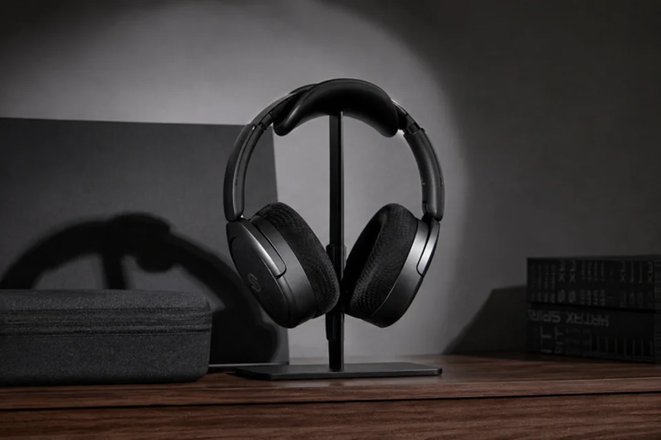 Edifier Stax Spirit S5 mit Mesh-Ohrpolstern auf einem Kopfhörerständer, daneben das Transportetui