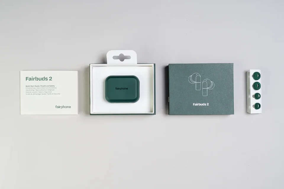 Lieferumfang der Fairphone Fairbuds 2: Kurzanleitung, grünes Ladecase in der Schachtel, Verpackung und Ohrpassstücke