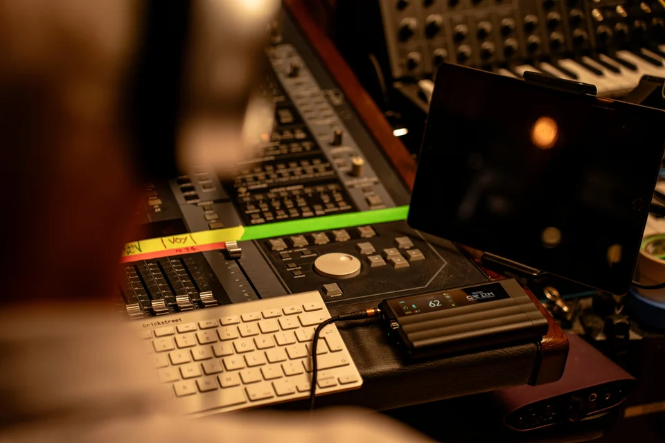 iFi iDSD GR 2 MT liegt per Kabel verbunden auf einem Studio-Mischpult neben einer Tastatur