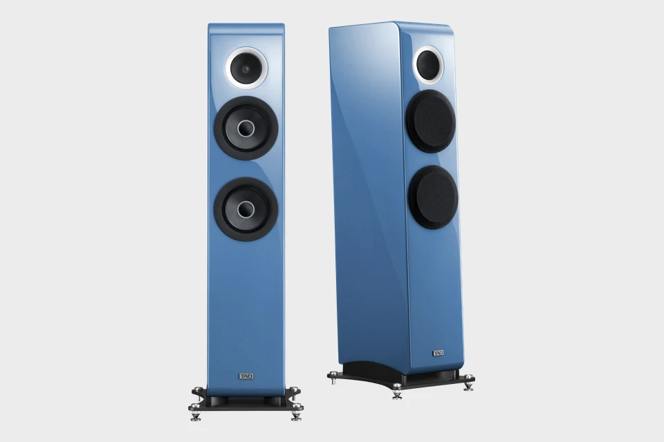 TAD E2 in Scandinavian Blue, einmal von vorn und einmal schräg mit Abdeckungen über den Tieftönern